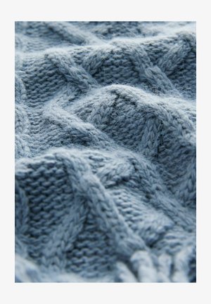 Svetlo modra pletena tkanina z dvignjenimi diagonali in kabelskimi vzorci, ki prikazuje mehak, teksturiran videz z finimi vlakni.