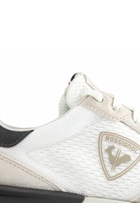 White and grey sneaker featuring a mesh upper, suede accents, and a rubber sole. Includes the Rossignol logo on the side.