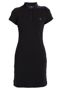 Robe polo noire en coton, avec un plastron à boutons, des manches courtes, une coupe ajustée et un petit logo sur la poitrine.