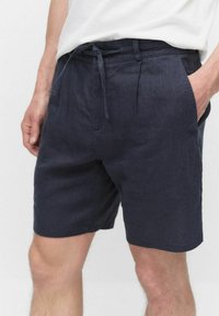 Marina linnenbyxor har en avslappnad passform, dragsko i midjan och sidofickor. Den texturerade tyget och knälängden är utformade för komfort.