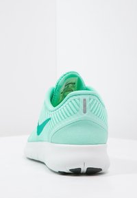Scarpa da ginnastica verde menta con tomaia in rete testurizzata, forma arrotondata, collarino imbottito e logo in un verde scuro a contrasto. Suola bianca con motivo minimo.