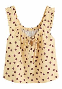 Gelbes ärmelloses Oberteil mit braunen Polka-Dots, Rüschen an den Trägern, gerafftem Ausschnitt und einer Vorderknotendetail.