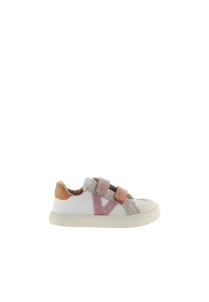 Zapatilla blanca de corte bajo con suela beige, correas de Velcro en rosa y beige, franja lateral rosa y parche en el talón color canela.