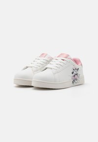 Vita sneakers med en rosa detalj på hälen, snörningsdesign och en tryckt bild av en tecknad karaktär på sidan.