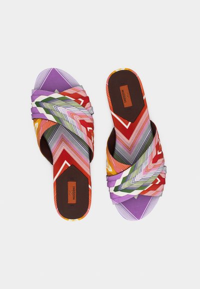 Sandales plates avec des bandes en tissu rayé rouge, violet, vert et blanc entrecroisées, avec un logo Missoni sur la semelle marron.