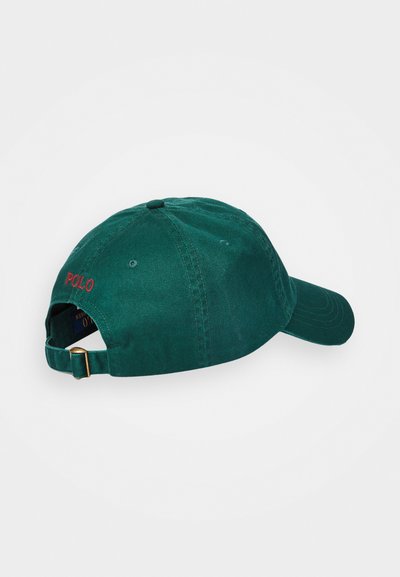 Green cotton cap with a curved brim, adjustable strap at the back, and "POLO" embroidered in red on the rear. Smooth texture.