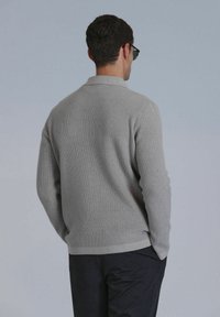 Gray ribbed knit sweater featuring a collared neckline and long sleeves, with a relaxed fit and a smooth texture.