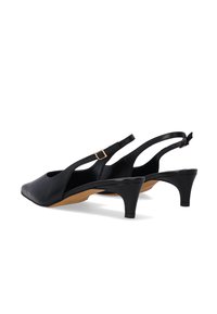 Black leather slingback shoes with a pointed toe, open sides, and a low, wide heel. Features a buckle accent on the strap.