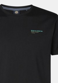 Černé bavlněné tričko s kulatým výstřihem. Na přední straně se nachází tyrkysový nápis "DRIVEN BY PETROL IND. MIAMI FLORIDA 1.9.8.9."