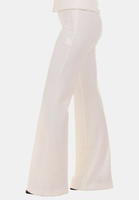 Pantaloni bianchi a sbuffo realizzati in un tessuto liscio, con vita alta e una vestibilità su misura, con cuciture laterali che si estendono fino all'orlo.