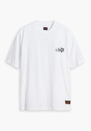 T-shirt blanc en coton, avec un logo noir "Levi's" sur la poitrine gauche et une petite étiquette de marque près de l'ourlet. Encolure classique et manches courtes.