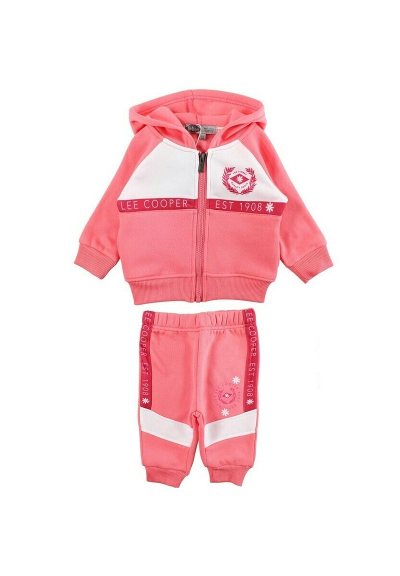 Survêtement deux pièces rose en tissu doux. Comprend un sweat à capuche zippé avec des accents blancs et un logo, associé à un pantalon à taille élastique.