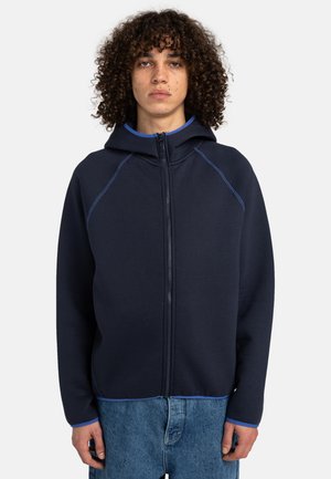 Navy zip-up hoodie with a fitted hood, blue accents, and raglan sleeves. Soft texture and casual fit, paired with light blue interior.