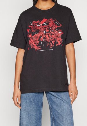 T-shirt en coton noir avec un imprimé graphique audacieux rouge représentant plusieurs personnages. Manches courtes et coupe décontractée.