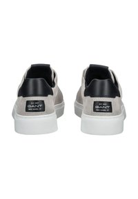 Pár šedých semišových tenisek s bílými podrážkami a černými záložkami na patě, zobrazující logo značky GANT a nápis "New Haven, CT" na zadní straně.