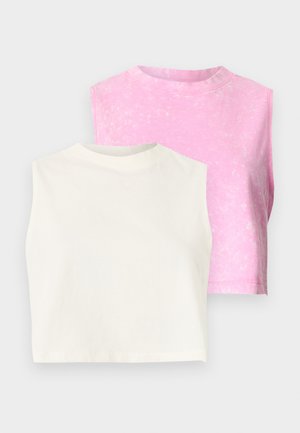 Deux hauts courts sans manches, l'un uni en blanc cassé à l'avant et l'autre à motif tie-dye rose à l'arrière, présentés sur un fond uni.