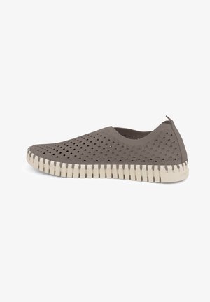 Zapato gris tipo slip-on hecho de material flexible con diseño cortado y suela texturizada beige. Presenta un perfil bajo y una pestaña en la parte trasera para facilitar el calzado.