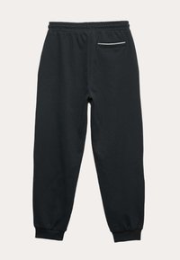 Schwarze Baumwoll-Sweatpants mit einem elastischen Bund, schmal zulaufenden Beinen und einer einzigen Gesäßtasche mit einem weißen Akzentstreifen.