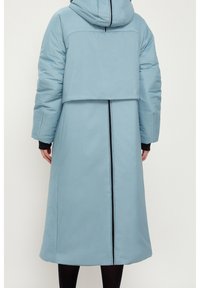 Cappotto piumino lungo con cappuccio in tessuto azzurro chiaro, colletto alto, zip nera sul retro e polsini a coste. Presenta un taglio ampio.