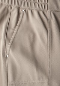 Beiga tygshorts med en texturerad yta, med en sidficka och kontrasterande sömmar. Elastisk midja ger flexibel passform.