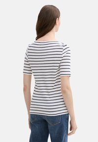 Stribet t-shirt i blødt, letvægtigt materiale; har marineblå striber på en hvid baggrund og en rund halsudskæring med korte ærmer.