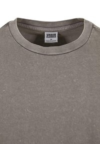 Tricou gri cu guler rotund, fabricat dintr-un amestec de bumbac. Caracteristici: textură moale, guler cusut și etichetă cu informații despre marcă și dimensiune.
