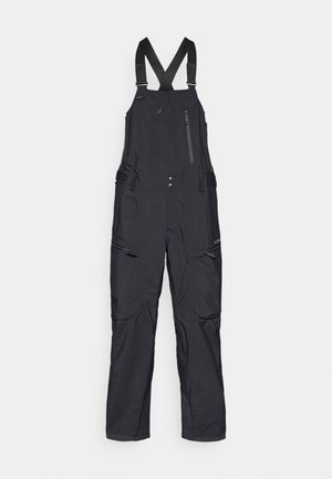 Black waterproof overalls with adjustable shoulder straps, zippered pockets, and reinforced knees. Smooth texture and straight leg design.