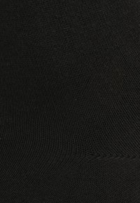Black cotton sock with a smooth texture and ribbed pattern. Features a reinforced toe and heel for durability. No visible branding.