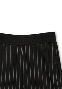 Pantalons noirs rayés avec une texture lisse, une taille élastique et des rayures blanches verticales pour une apparence ajustée.