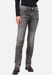 Jeans in denim nero sbiadito con una vestibilità slim, dotati di cinque tasche, chiusura frontale con bottone e cuciture a contrasto. Texture liscia in tutto il capo.