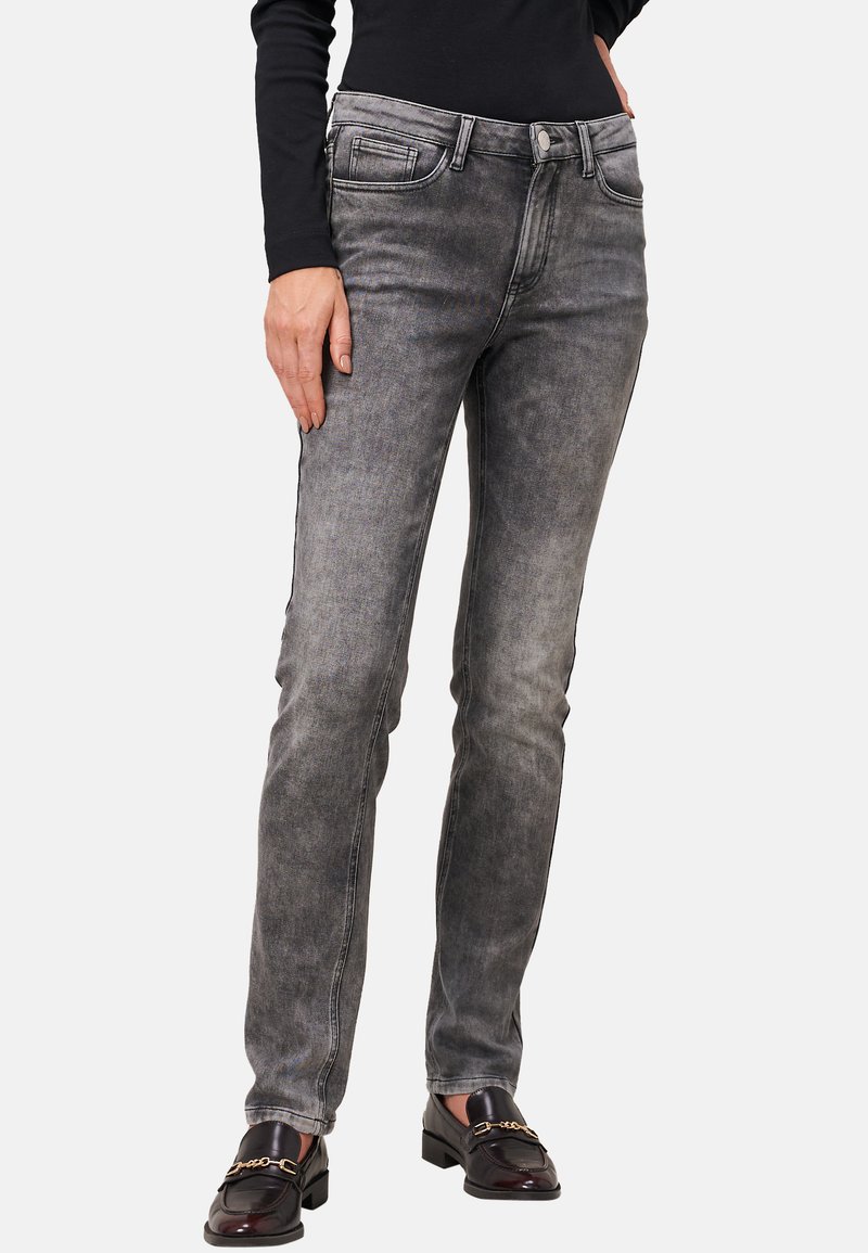 Jeans in denim nero sbiadito con una vestibilità slim, dotati di cinque tasche, chiusura frontale con bottone e cuciture a contrasto. Texture liscia in tutto il capo.