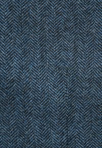 Stoff mit Fischgrätmuster in dunkelblauen und grauen Tönen, der eine strukturierte Webart mit sanfter Haptik und sichtbaren Fadendetails aufweist.