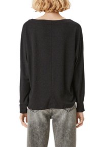 Svart, långärmad topp med vid halsringning och lös passform. Tyget har en subtil glans; baksidan har en central söm.