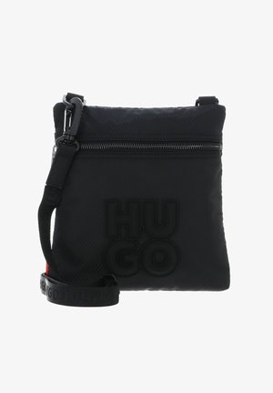 Sac bandoulière noir en tissu texturé, avec une fermeture éclair sur le dessus, un logo embossé et une sangle ajustable. Détails en rouge.