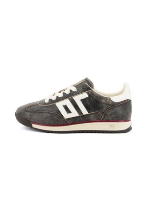Zwart-witte retro sneaker met witte veters, een zigzagpatroon aan de zijkant en een bordeauxrode streep boven de zool.