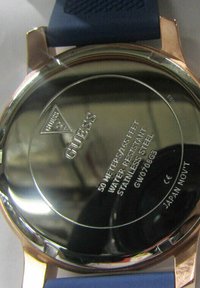 Orologio Guess con fondo lucido in acciaio inox, dotato di cinturino in gomma blu. Il testo include dettagli sulla resistenza all'acqua e il logo del marchio.