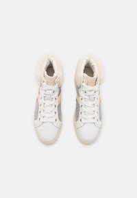 Hoge sneakers met witte leren en grijze suède panelen, een luxe crèmekleurige nepmof, gouden hardware en witte veters.