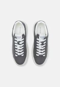 Baskets en cuir gris avec des semelles blanches. Caractéristiques : lacets blancs, un logo sur la languette et un design épuré. Accents texturés sur les côtés.