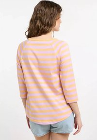 Gestreiftes Dreiviertelärmeltop aus weichem Baumwollstoff, mit abwechselnden lila und gelben Streifen, Rundhalsausschnitt und abgerundetem Saum.