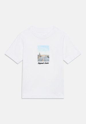 White short-sleeve t-shirt with a road and trees graphic and "Originals Studio" text centered on the front.