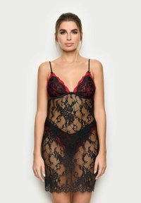 Vestaglia in pizzo nero con accenti rossi, caratterizzata da un design trasparente, sottili spalline nere e intricate fantasie floreali.