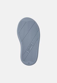 Suola di scarpa in gomma di colore azzurro chiaro, con un motivo a battistrada ondulato e il logo "CAMPER" inciso. Il design è fluido con una forma arrotondata.
