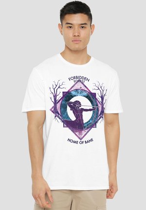 Man wearing white t-shirt with purple graphic of archer aiming bow, bare trees, and text "Forbidden Forest Home of Bane" on front.
