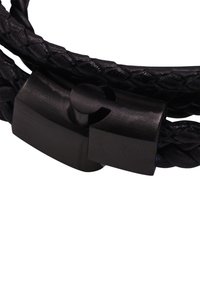 Bracciale in pelle intrecciata nera con chiusura dal finish opaco e liscio. Il design include una lavorazione intricata e un meccanismo di chiusura arrotondato.