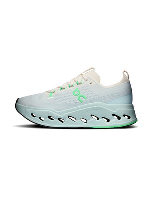 Chaussure de course blanche et bleu clair avec des accents verts, semelle épaisse avec découpes ovales et une boucle au talon, vue de côté.
