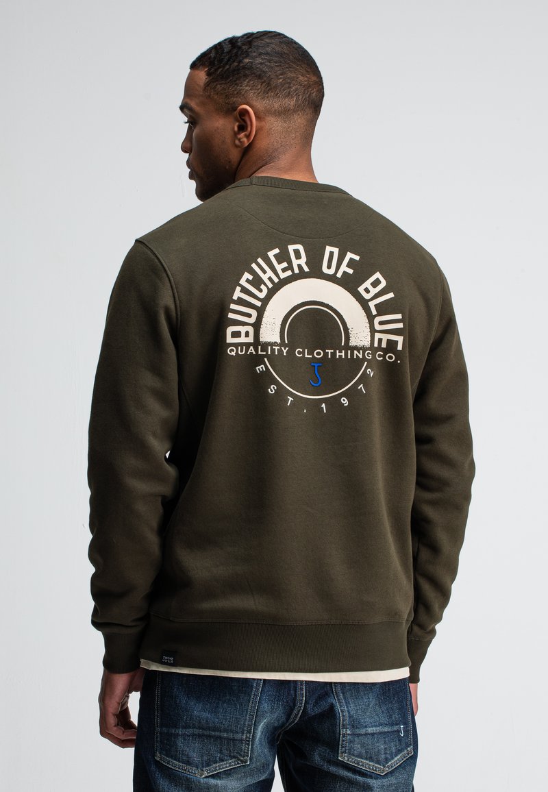 Militair groene sweatshirt met een ronde hals. Bevat een grote grafische print op de achterkant met "BUTCHER OF BLUE" in het wit. Geribbelde manchetten en zoom.
