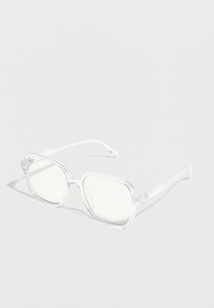 Läbipaistev ruudukujuline prilliraam, millel on selged läätsed, toetudes helehallile pinnale, näidates õrnaid varje.