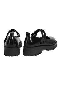 Schwarze Lacklederschuhe mit runder Schuhspitze und zwei verstellbaren Riemen. Dicke Gummisohle mit strukturiertem Profil.