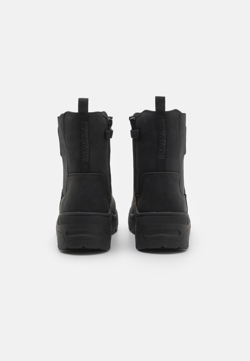 Stivali alla caviglia neri con una morbida texture in suede, cerniere laterali e suole in gomma. Dotati di piccoli manici per facilitare l'indossamento.