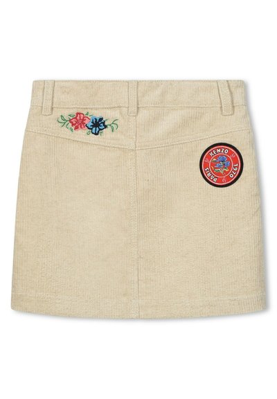 Jupe mini en velours côtelé beige avec broderie florale en rouge et bleu, ornée d'un patch circulaire du logo Kenzo sur le côté avant droit.